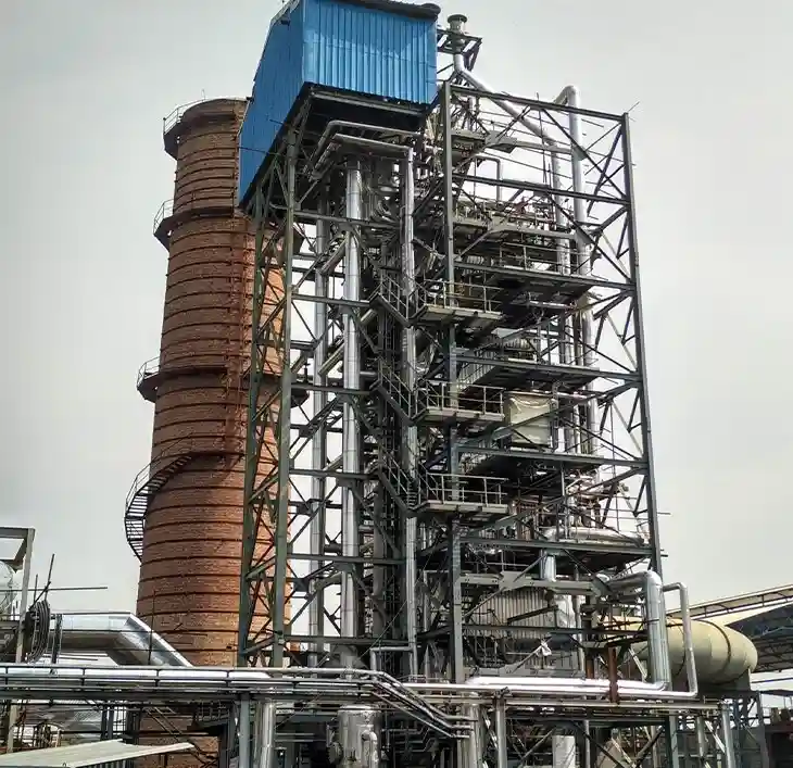High-elevation structural steel process tower and brick chimney stack integrated within a heavy engineering coke oven plant facility.